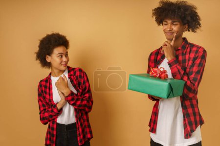 Téléchargez les photos : Joyeux et joyeux couple échange cadeau de Noël - en image libre de droit