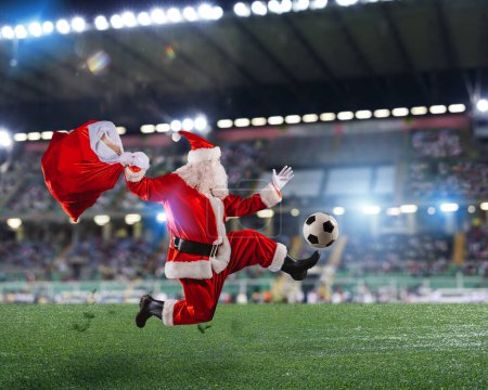 Photo for Santa claus runs fast with a soccer ball in a football match - Royalty Free Image