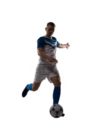 Téléchargez les photos : Joueur de football donne un coup de pied au ballon de football prêt à jouer - en image libre de droit