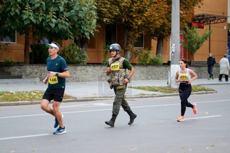 Photo for BILA TSERKVA, UKRAINE - OCTOBER 6: The running participant of Bila Tserkva Marathon is in accoutrement of Ukrainian Army which weight more then 20 kg on October 6, 2019 in Bila Tserkva, Ukraine. - Royalty Free Image