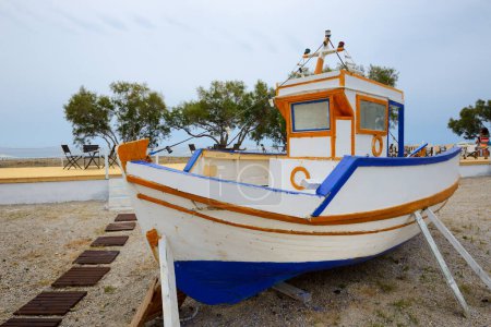 Photo for The traditional Greek motor boat is on a beach, Santorini island, Greece - Royalty Free Image