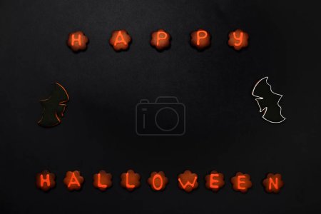 Photo for The hand-made eatable gingerbread Halloween inscription and bats on black background - Royalty Free Image