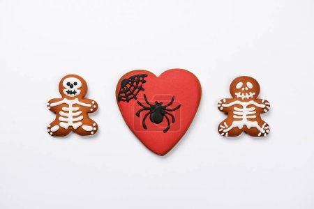 Photo for The hand-made eatable gingerbread heart with spider and sceletons on white background - Royalty Free Image