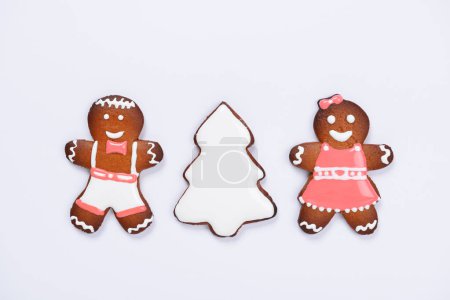 Photo for The hand-made eatable gingerbread little men and New Year Tree on white background - Royalty Free Image