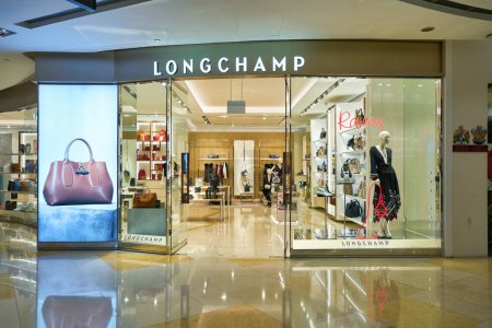 Foto de SINGAPUR - CIRCA ENERO 2020: Tienda Longchamp en el centro comercial ION Orchard en Singapur. Longchamp es una empresa francesa de artículos de cuero de lujo. - Imagen libre de derechos