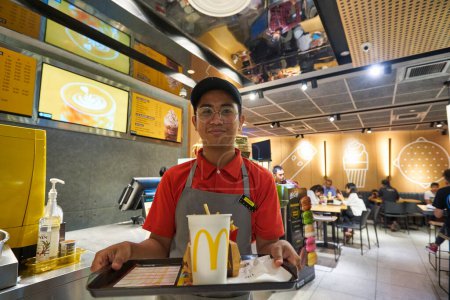 Foto de KUALA LUMPUR, MALASIA - CIRCA ENERO 2020: retrato interior del trabajador en el restaurante McDonald 's en Kuala Lumpur. - Imagen libre de derechos