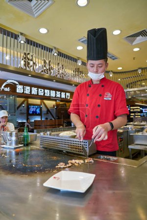 Photo for SHENZHEN, CHINA - CIRCA NOVEMBER, 2019: cook preparing food at restaurant in food republic at KK mall in Shenzhen. - Royalty Free Image