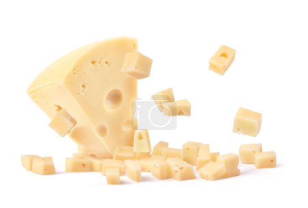 Ein großes Stück Käse wird isoliert auf weißem Hintergrund in kleine Stücke zerlegt