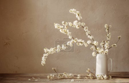 Photo for Cherry flowers in white jug on old wooden table - Royalty Free Image