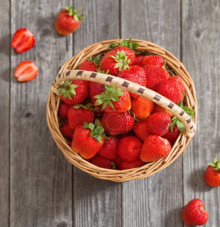 Photo for Strawberries in a basket on wooden table - Royalty Free Image