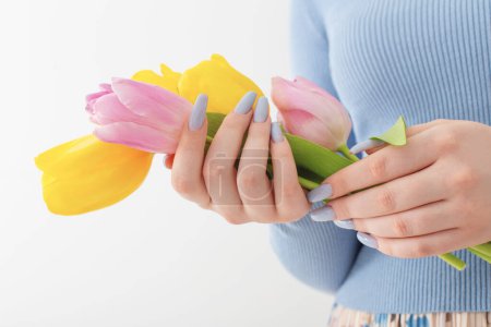 Téléchargez les photos : Jeune fille avec bouquet de tulipes sur fond blanc - en image libre de droit