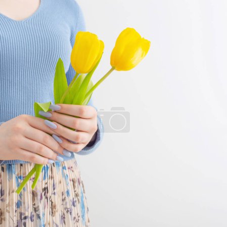 Téléchargez les photos : Jeune fille avec bouquet de tulipes sur fond blanc - en image libre de droit