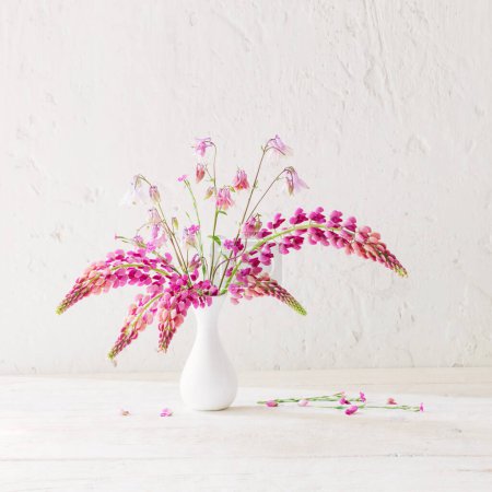 Photo for Pink summer flowers in white vase on white old background - Royalty Free Image