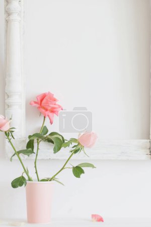Photo for Pink roses in vase on background white wall - Royalty Free Image
