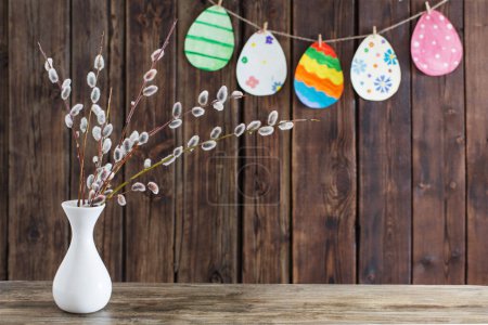 Foto de Huevos de papel pintado de Pascua con ramas de sauce sobre fondo de madera - Imagen libre de derechos
