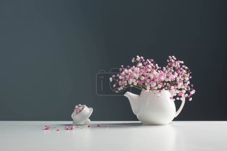 Photo for Pink gypsophila in white teapot on background gray wall - Royalty Free Image