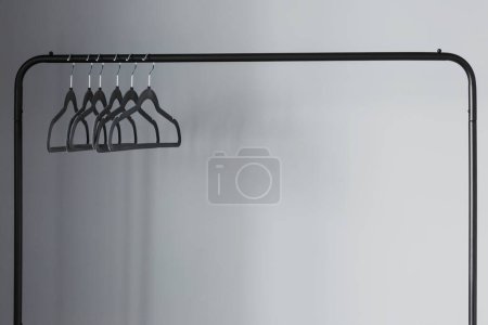 Photo for Empty black clothes hanger on gray wall background - Royalty Free Image
