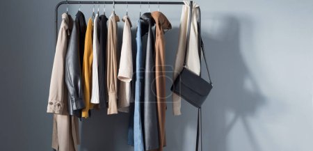 Herbst-Garderobe für Frauen mit Schuhen und Handtaschen am Kleiderbügel