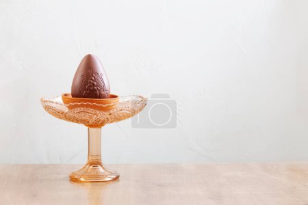 Foto de Huevo de Pascua de chocolate en el plato sobre fondo blanco - Imagen libre de derechos