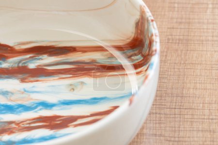 Foto de Cuenco multicolor de cerámica de cerca en la mesa de madera - Imagen libre de derechos