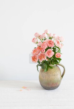 Téléchargez les photos : Bouquet de roses pivoines dans une cruche en céramique sur fond blanc - en image libre de droit