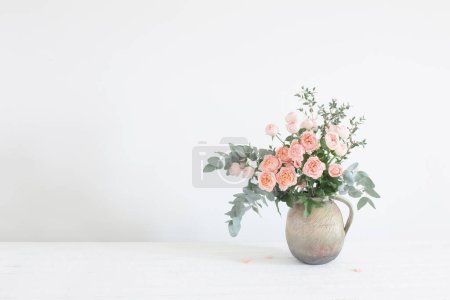 Foto de Ramo de rosas de peonía en jarra de cerámica sobre fondo blanco - Imagen libre de derechos