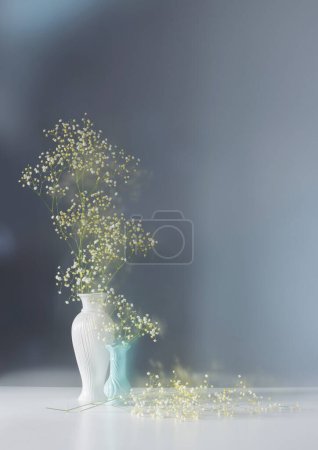 Photo for Gypsophila flowers in white vase on blue background - Royalty Free Image