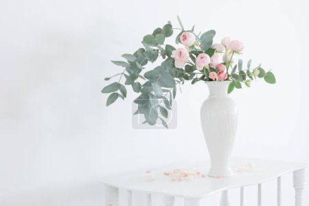 Photo for Bouquet of pink roses in ceramic white vase  on white vintage wooden shelf - Royalty Free Image