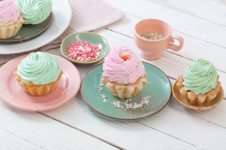 Téléchargez les photos : Cupcakes sur assiettes sur fond bois blanc - en image libre de droit