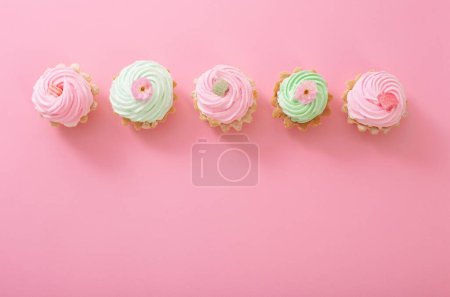 Téléchargez les photos : Cupcakes roses et verts sur fond rose - en image libre de droit