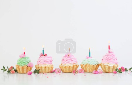 Téléchargez les photos : Cupcakes roses et verts avec des fleurs printanières sur fond blanc - en image libre de droit