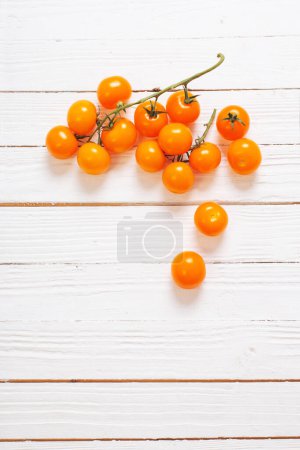 Téléchargez les photos : Tomates orange cerise sur fond blanc en bois - en image libre de droit