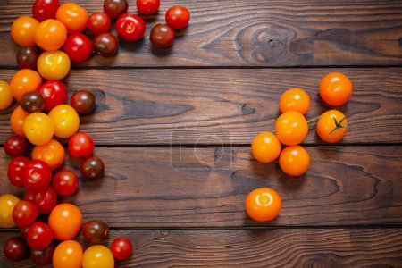Photo for Various tomatoes on dark wooden table - Royalty Free Image