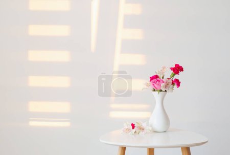 Foto de Flores en jarrón blanco sobre fondo blanco a la luz del sol - Imagen libre de derechos