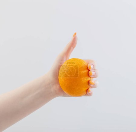 Téléchargez les photos : Mains féminines avec orange sur fond blanc - en image libre de droit