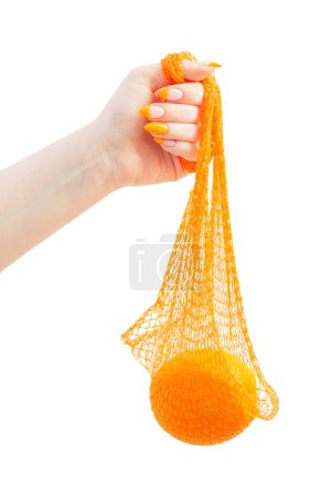 Photo for Female hand with orange and synthetic string bag isolated on white background - Royalty Free Image