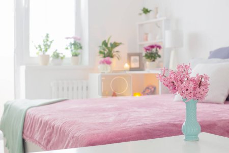 Téléchargez les photos : Intérieur rose et blanc de la chambre à coucher avec fleurs printanières - en image libre de droit
