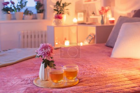 Téléchargez les photos : Chambre confortable en soirée avec des fleurs et du thé - en image libre de droit