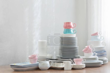 Foto de Cubiertos de color rosa, blanco abd azul sobre una mesa de madera contra una pared blanca - Imagen libre de derechos