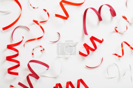Téléchargez les photos : Fond d'anniversaire avec serpentine rouge sur blanc - en image libre de droit