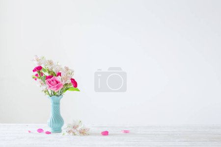 Photo for Pink and white flowers in blue vase on white background - Royalty Free Image