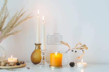 Téléchargez les photos : Décoration d'automne à la maison avec des bougies allumées - en image libre de droit