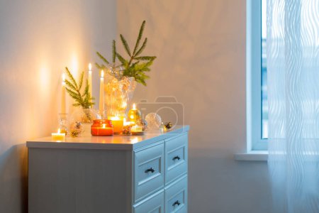 Photo for Christmas decorations with burning candles in white room - Royalty Free Image