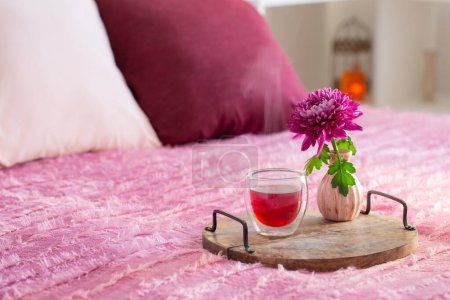 Téléchargez les photos : Thé rouge en verre thermique avec des fleurs dans la chambre moderne - en image libre de droit