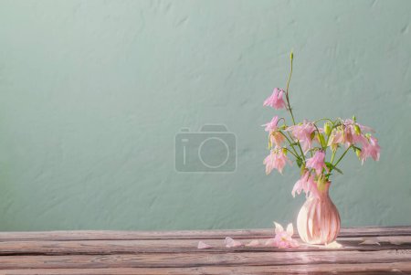 Foto de Flores de color rosa en florero rosa en la pared de fondo verde - Imagen libre de derechos