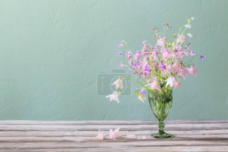 Photo for Wild flowers in green  bocal  on background green wall - Royalty Free Image