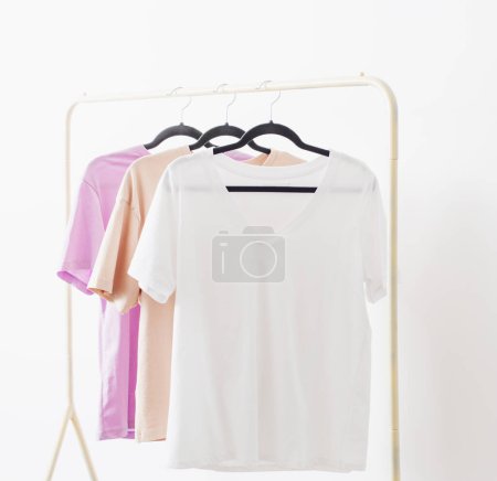 Téléchargez les photos : T-shirts femme sur cintre sur fond blanc - en image libre de droit