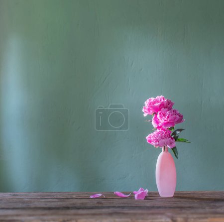 Photo for Pink peonies in pink vase  on green background - Royalty Free Image