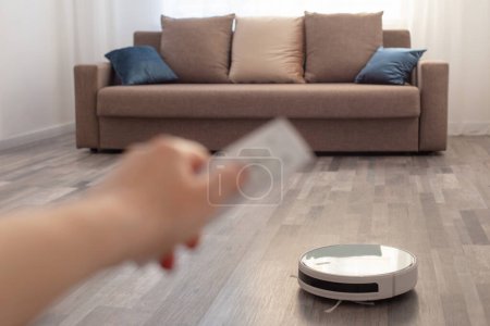 Foto de Aspiradora robot en el suelo en la sala de estar - Imagen libre de derechos
