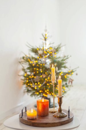 Téléchargez les photos : Brûler des bougies sur la table sur le fond arbre de Noël à la maison - en image libre de droit